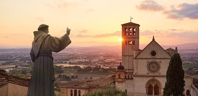 Estátua de São Francisco de Assis / Basílica de São Francisco de Assis, em Assis (Itália), fotomontagem MSA / iStockPhoto